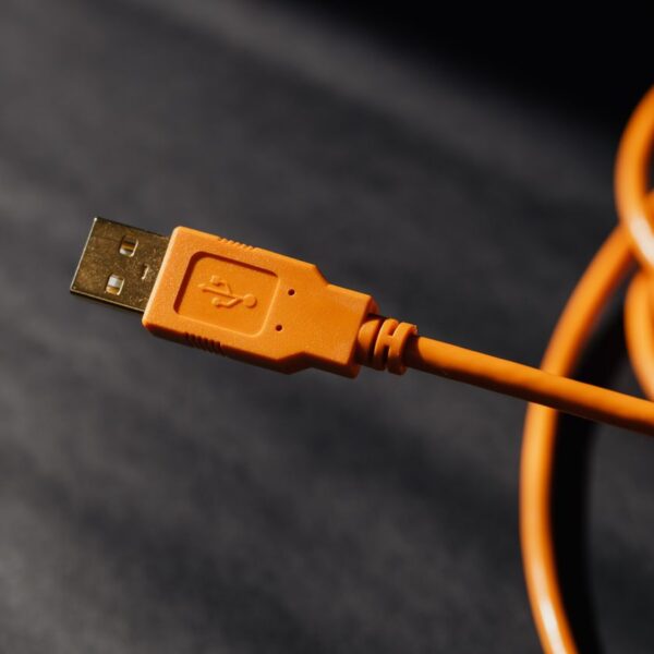 Detailed macro photo of an orange USB cable connector with focus on texture.
